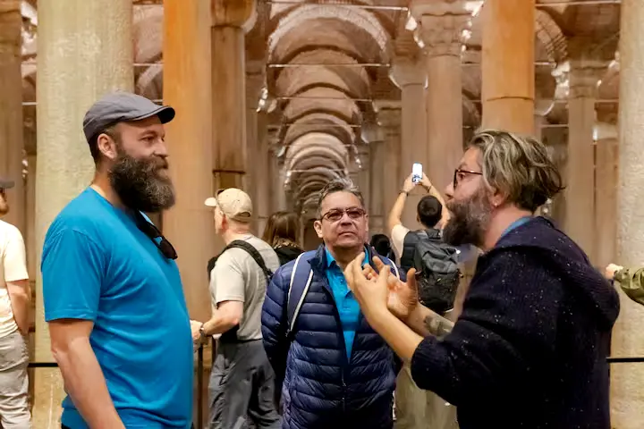 Professional tour guide explaining the history of Neolithic pillars to visitors
